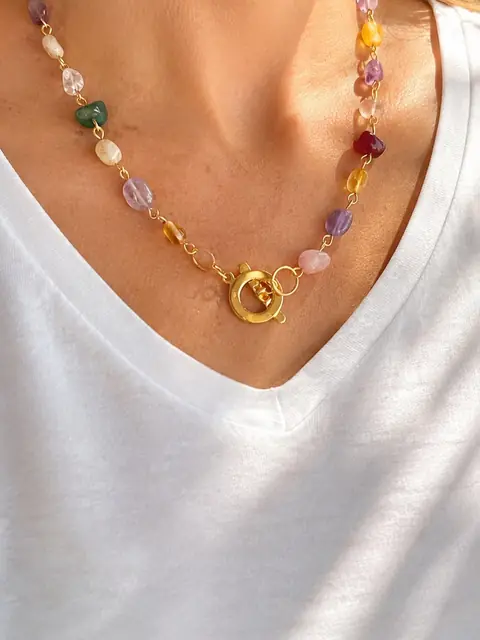 Wrap bracelet de cuentas de colores usado como collar sobre una camiseta blanca